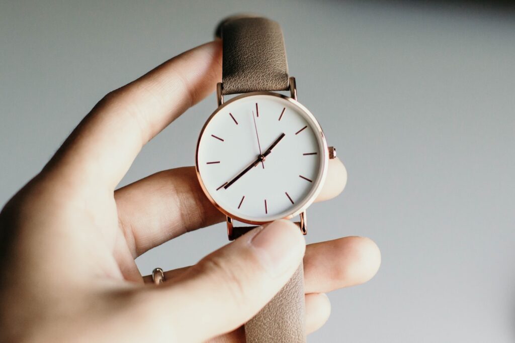 person holding analog watch